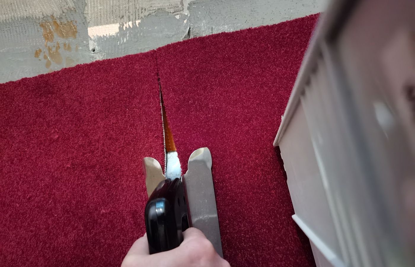 Einpassen des Teppichläufers an der Treppenwange von Hand