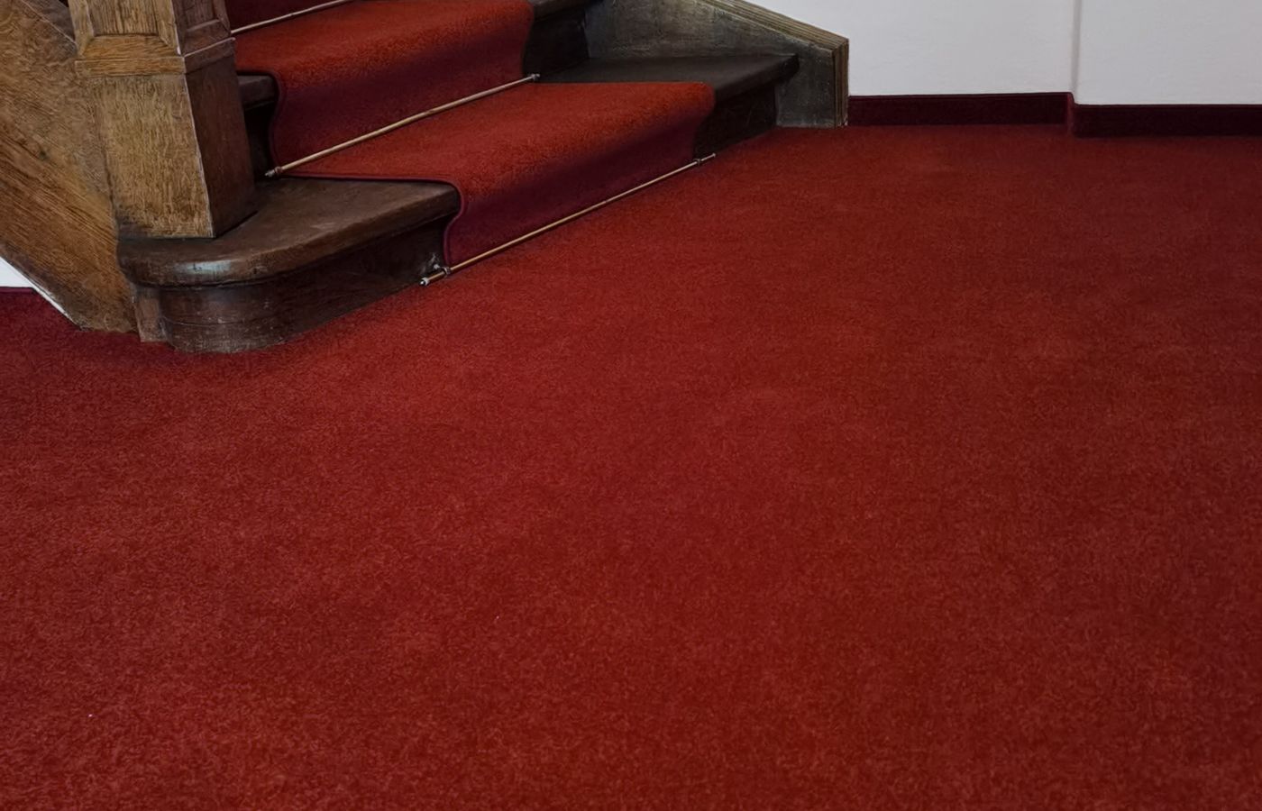 Roter Teppichläufer auf gewendelter Treppe, fertiggestellt