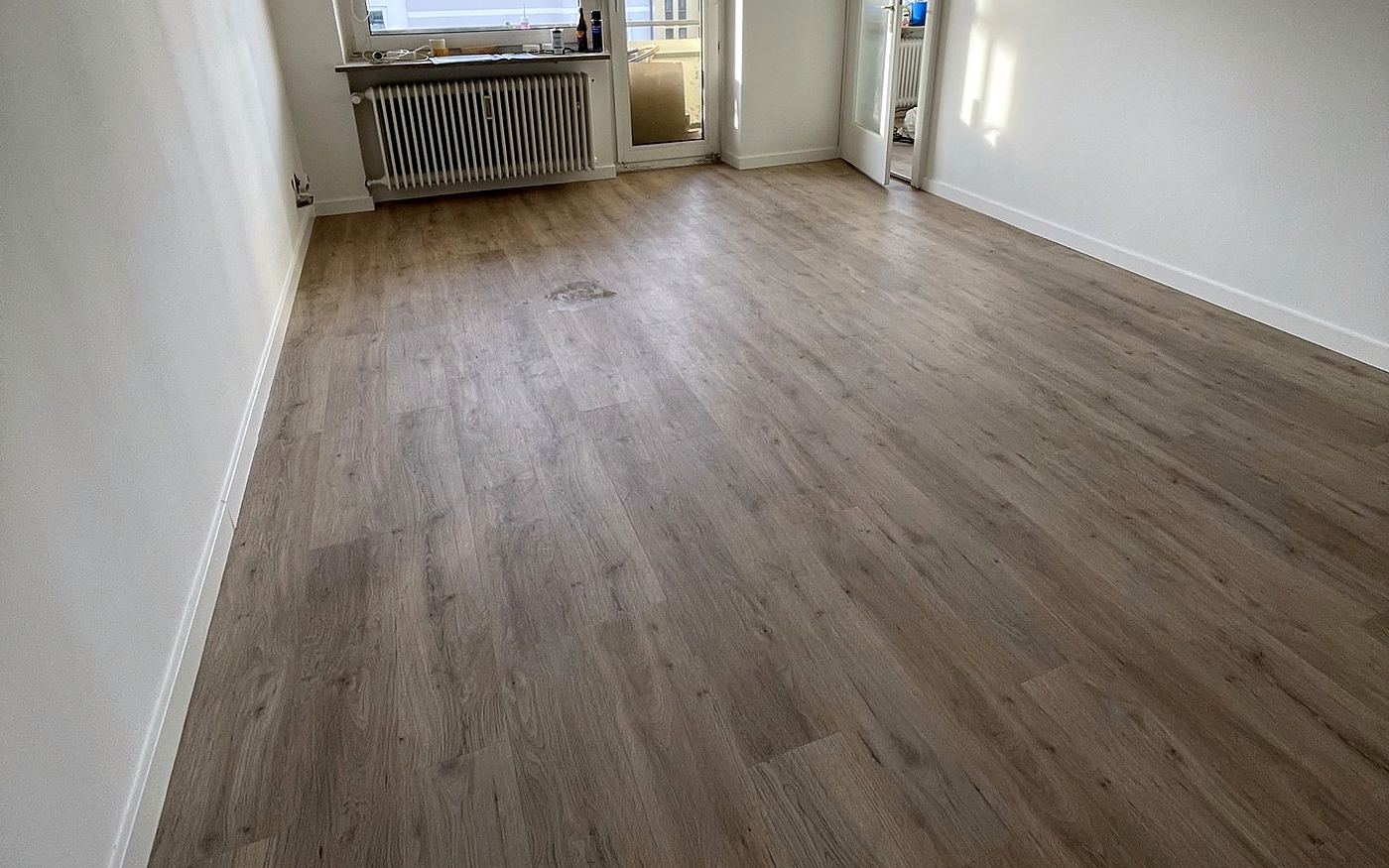 Derselbe Wohnraum mit Designboden aus der Gegenperspektive zum Fenster
