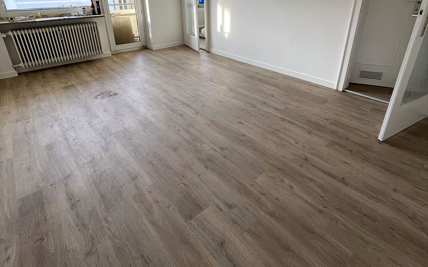 Großer heller Wohnraum in München mit verlegtem Designboden in Holzoptik