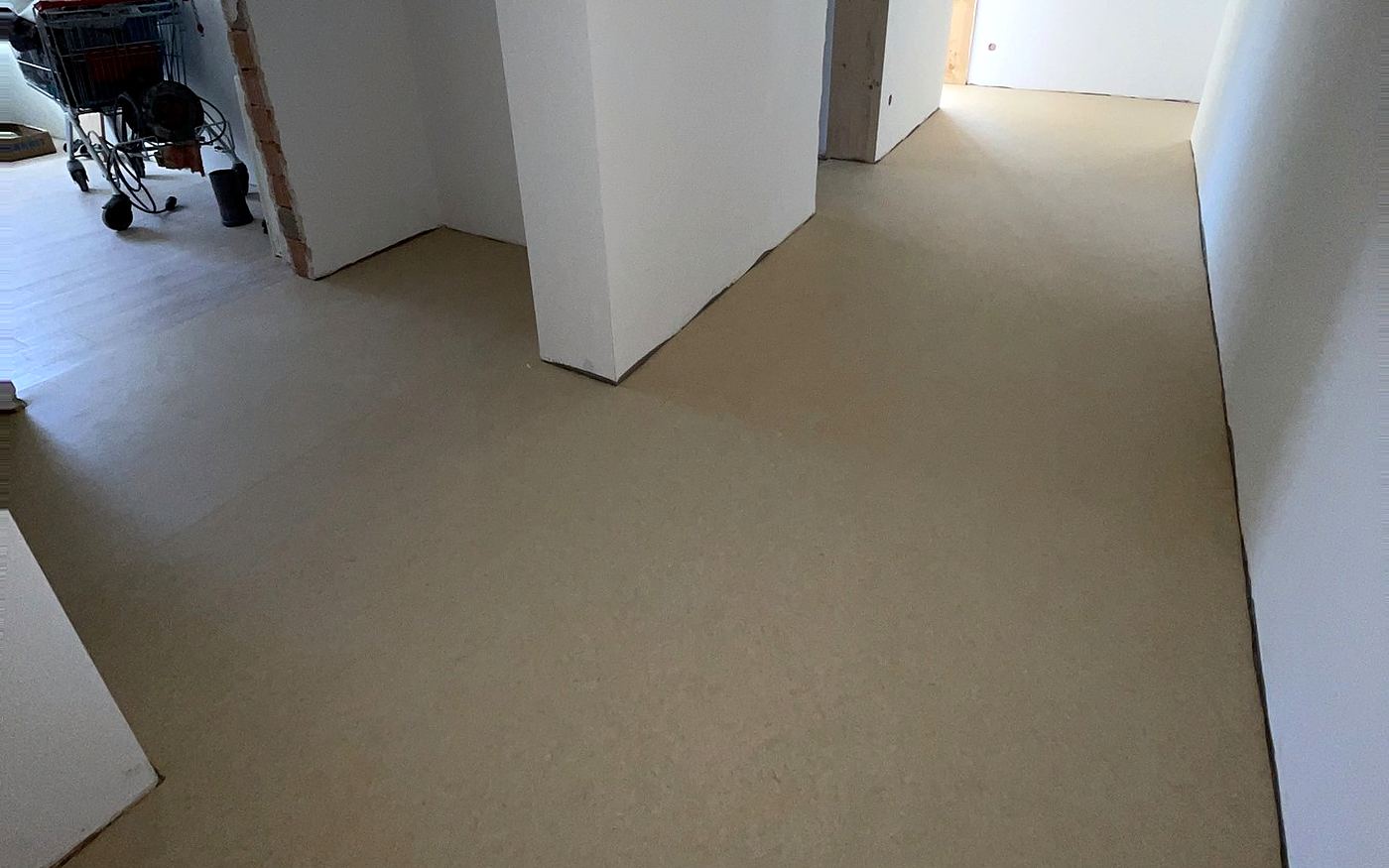 Fertig gespachtelte, gleichmäßig glatte Bodenfläche in einem Flur in München