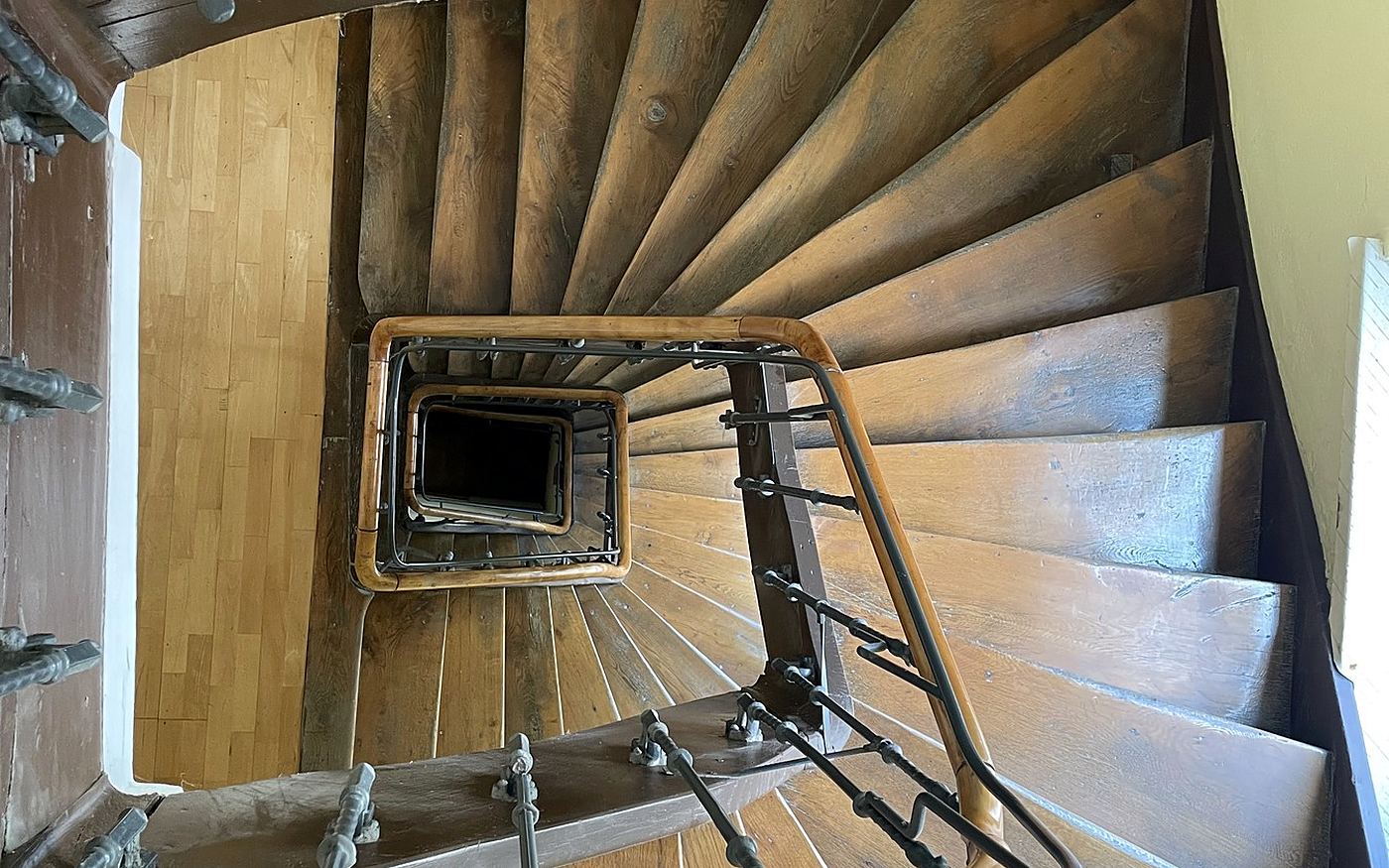Blick von oben in eine gewendelte Treppe mit neuen Holzstufen in München