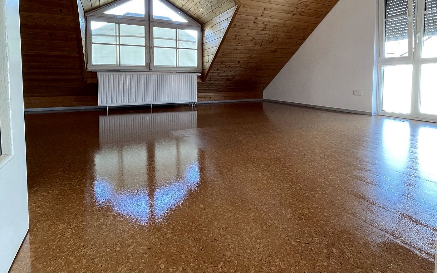 Großer Dachraum in München mit frisch versiegeltem Korkboden und Holzdecke
