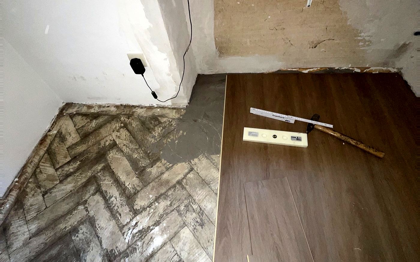 In ein altes Fischgrätparkett eingesetztes neues Dielenfeld während der Reparatur