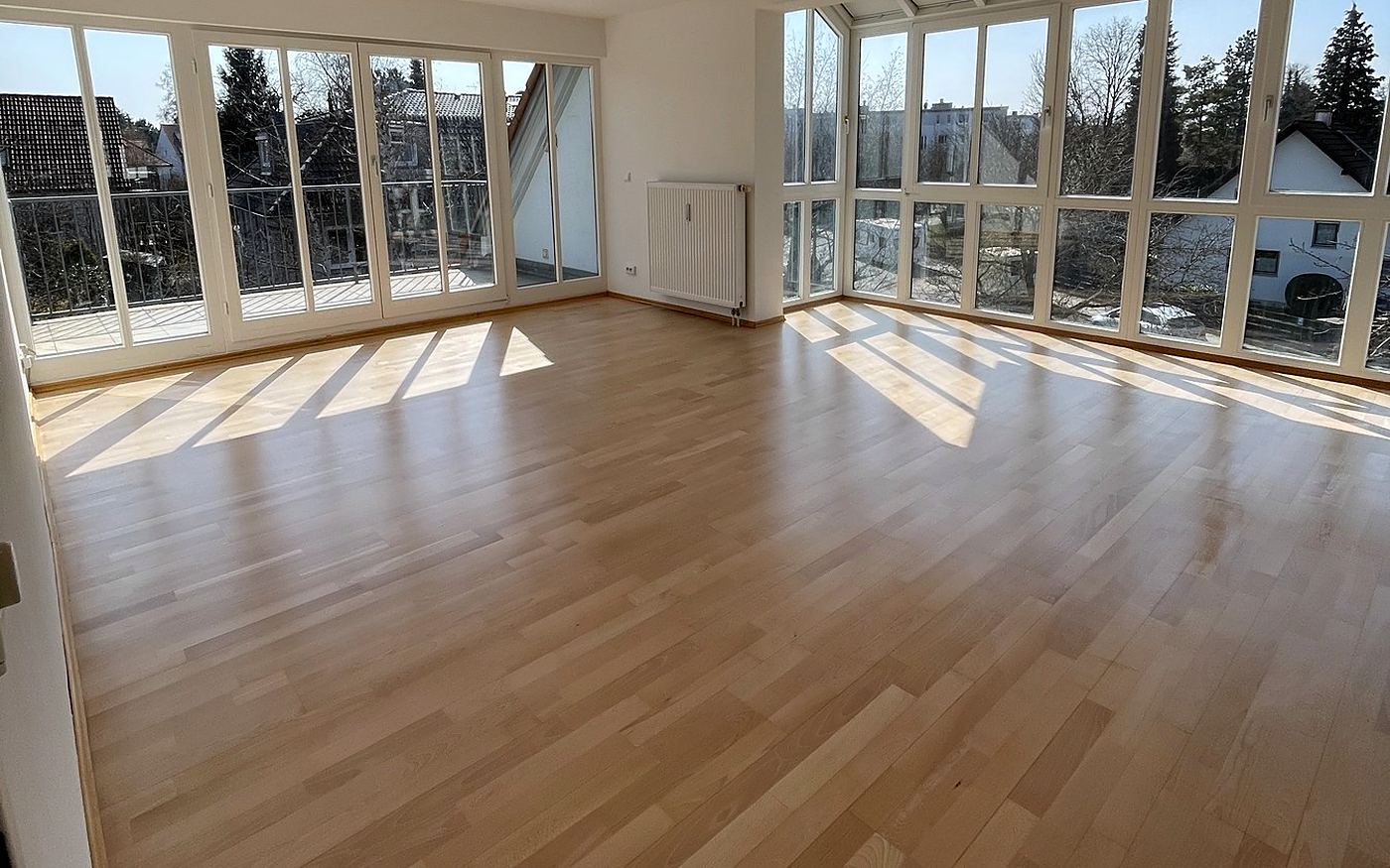Wohnraum in München mit Parkettboden und großer Fensterfront