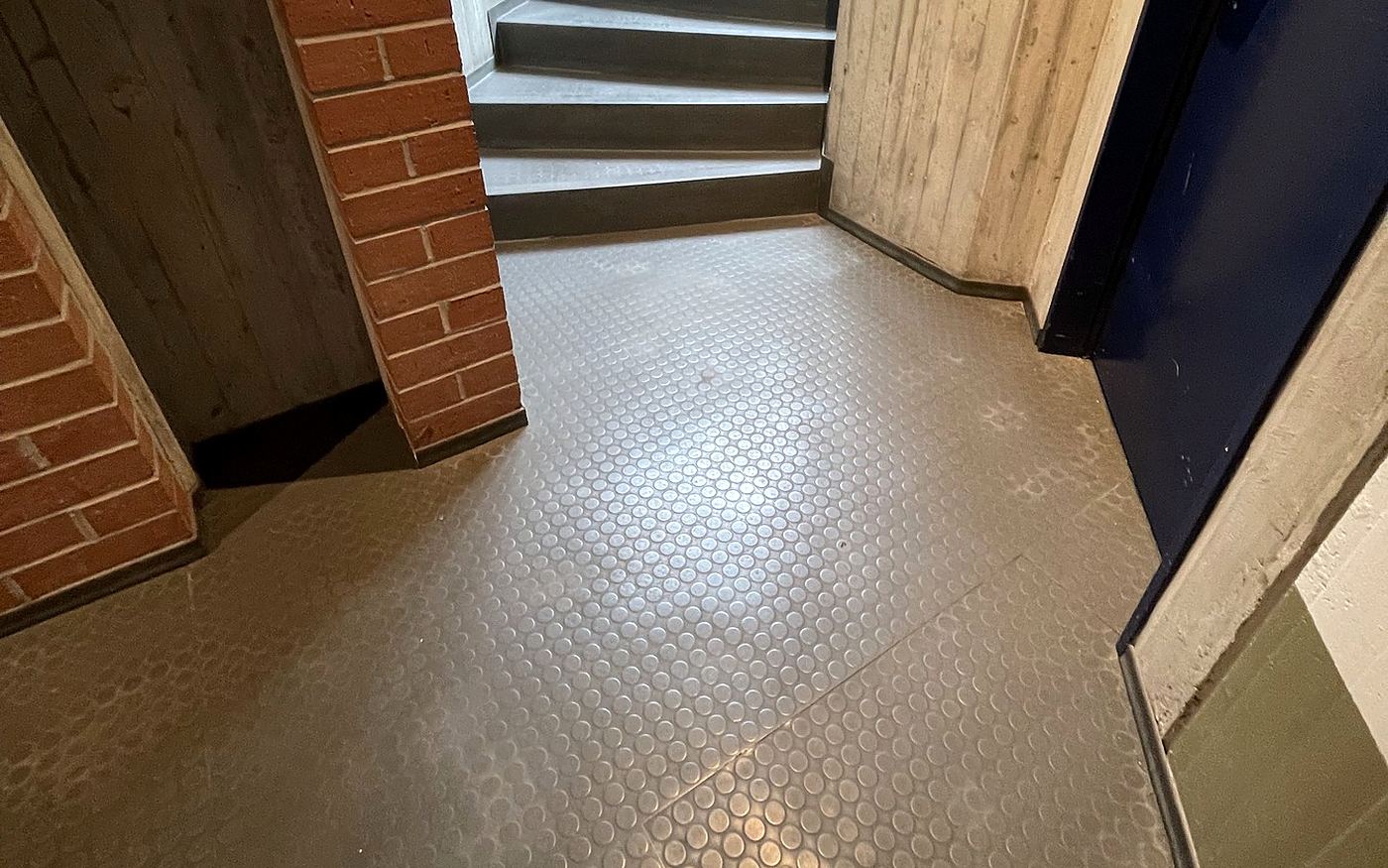Schulflur in München mit Noppenbelag und angrenzender Treppe