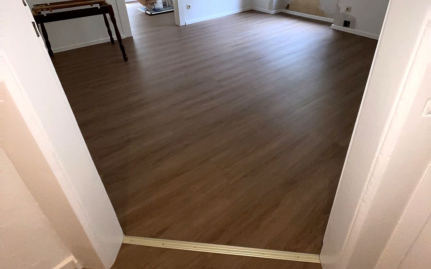 Zimmer in München mit Designboden und umlaufender weißer Sockelleiste an den Wänden