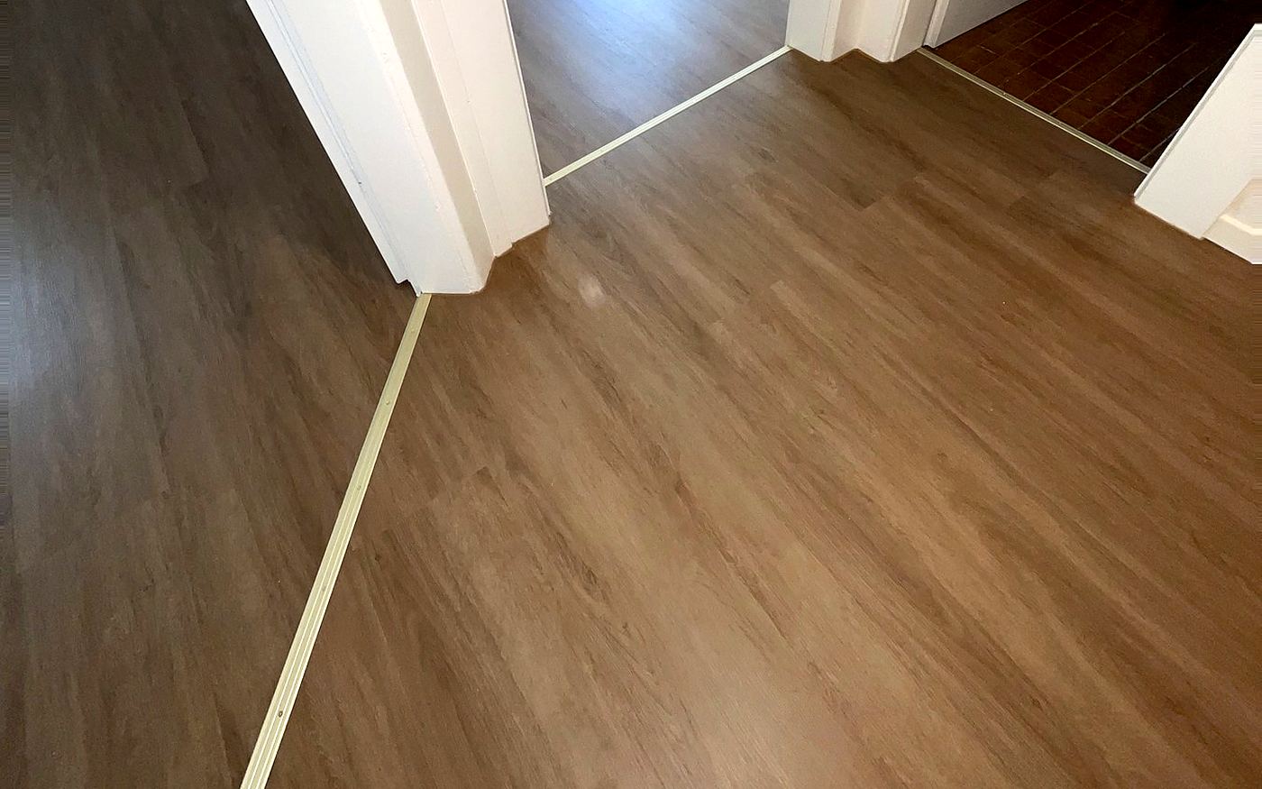 Fertiger Designboden mit heller Schwellenleiste im Türdurchgang in einer Wohnung in München