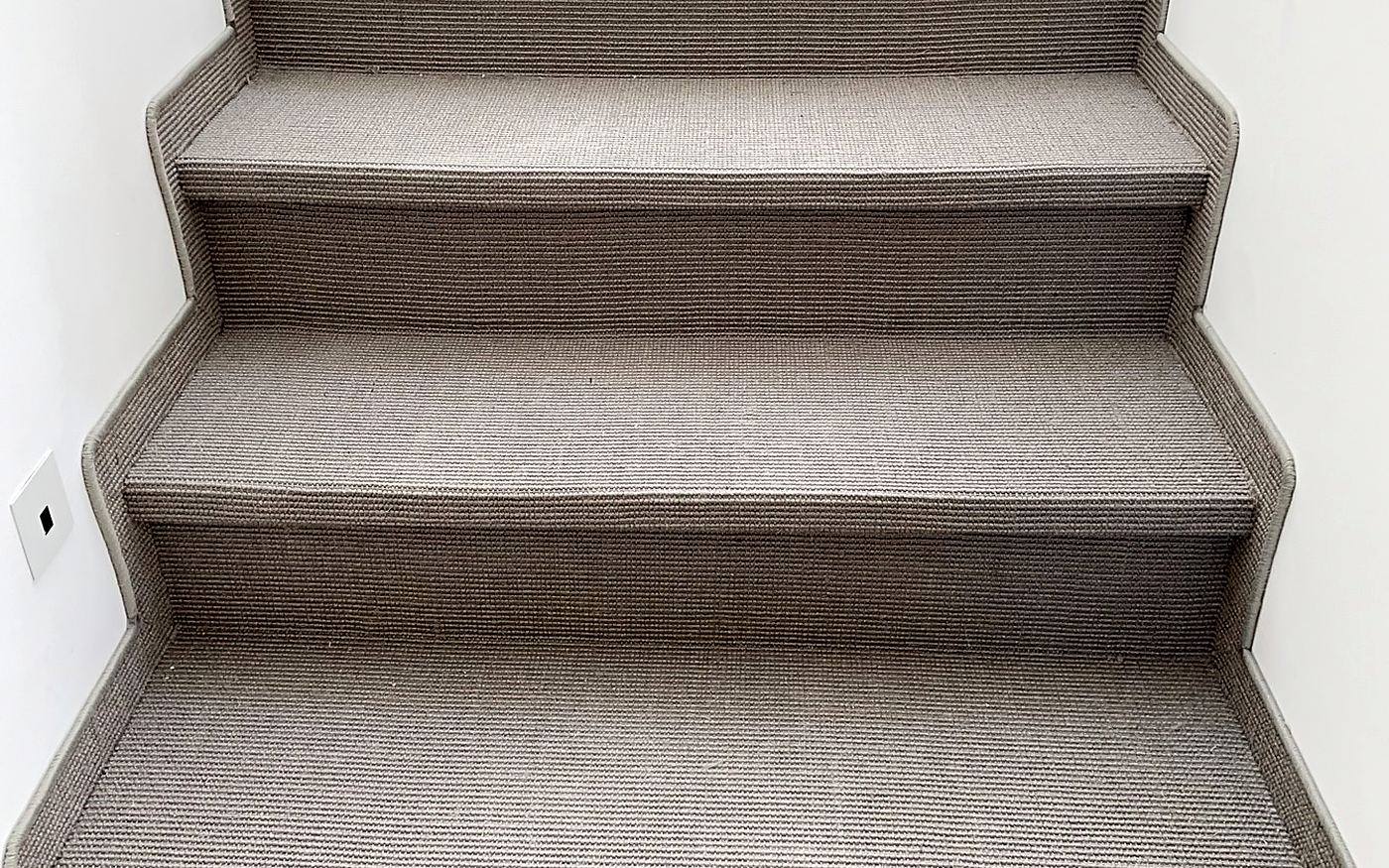 Frontale Ansicht einer Treppe mit sauber bezogenen Teppichstufen