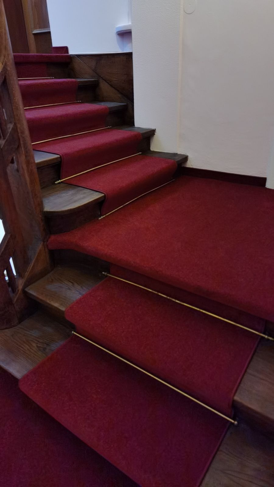 Mit Teppich belegte Holztreppe mit Messingstangen – Bodenleger München